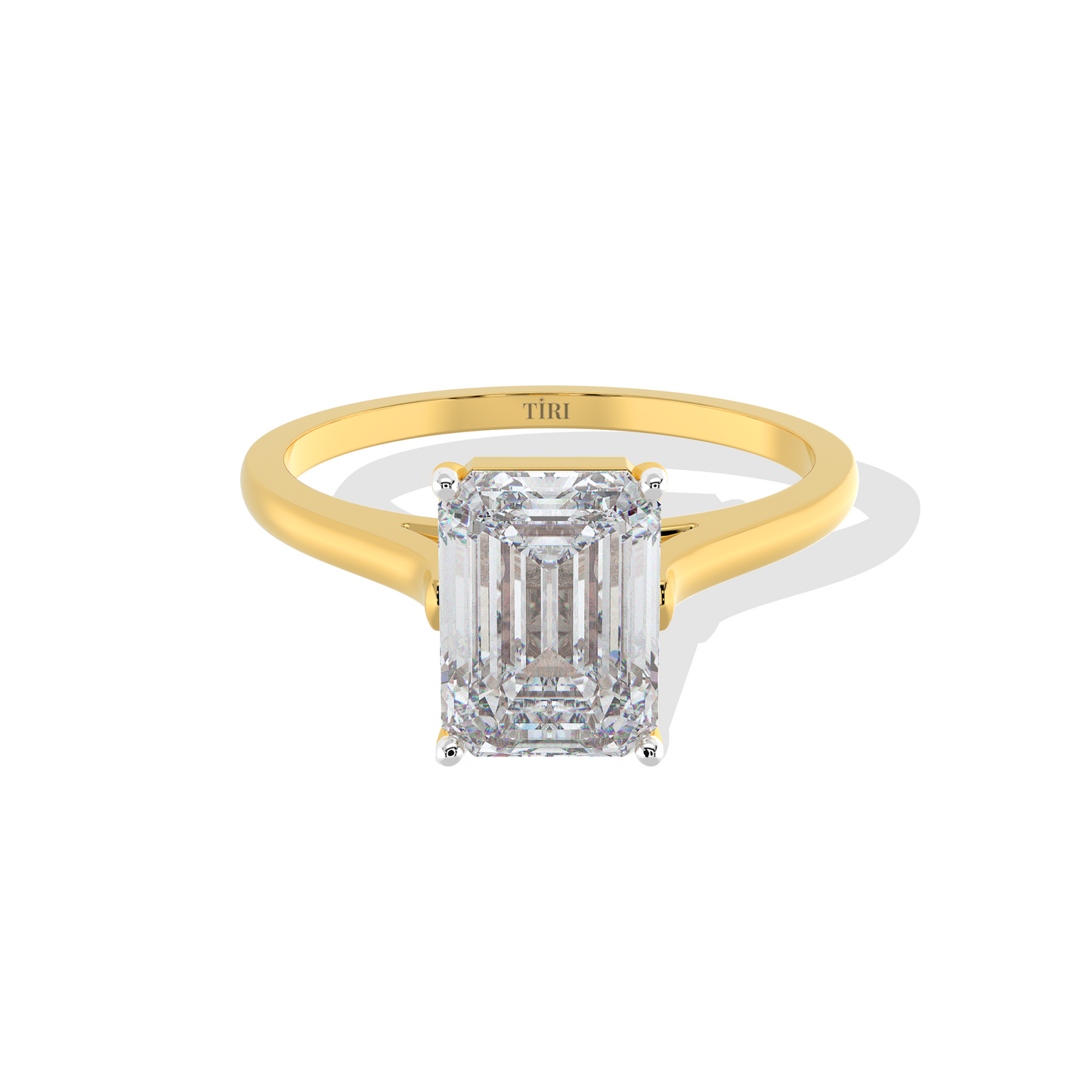 Emerald-cut solitaire diamond ring set in yellow gold.