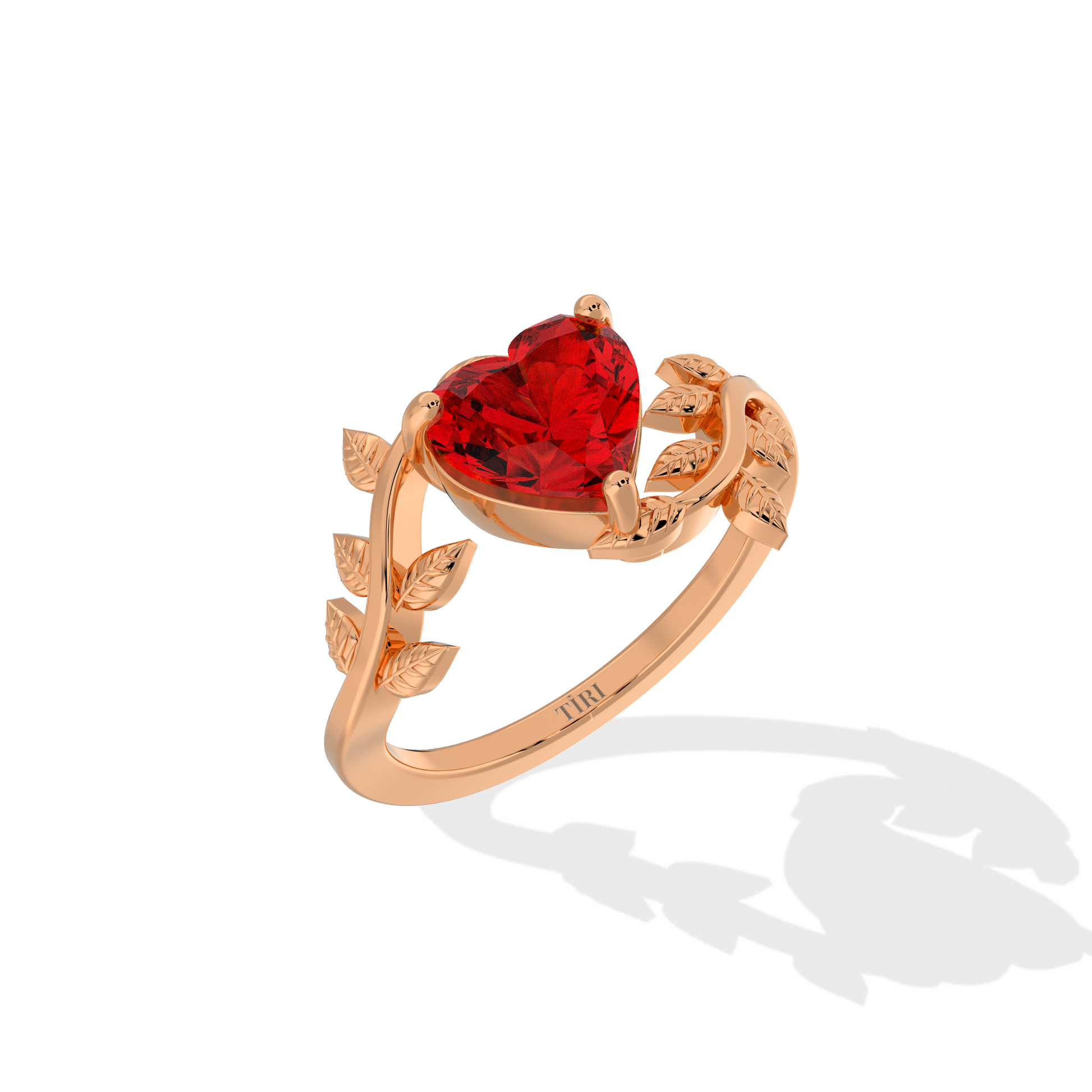 Heart-shaped red gemstone ring with diamond leaf accents.