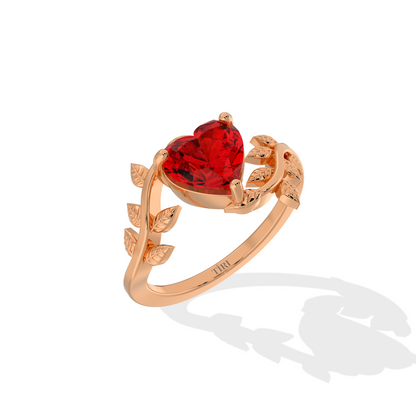 Heart-shaped red gemstone ring with diamond leaf accents.