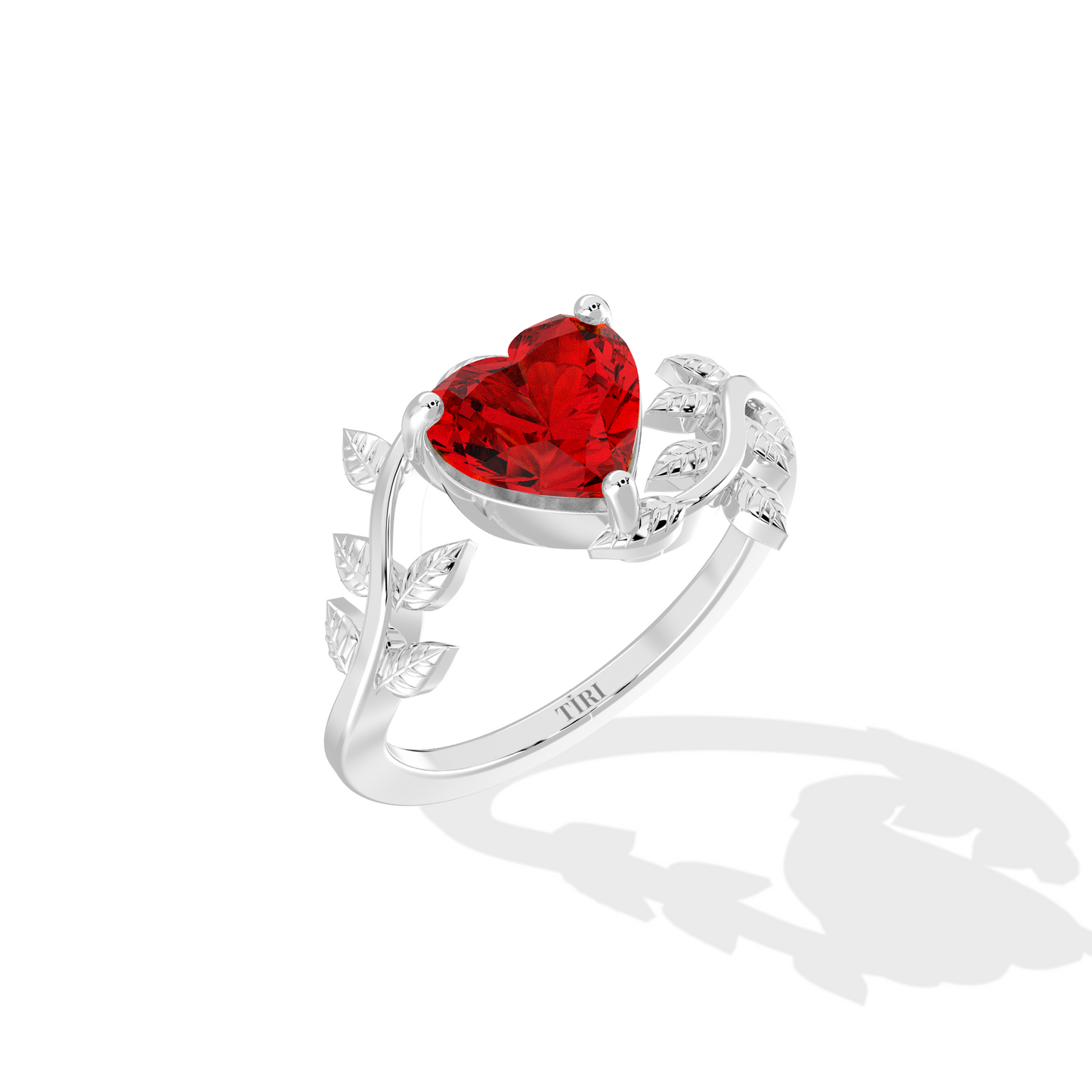 Heart-shaped red gemstone ring with diamond leaf accents.