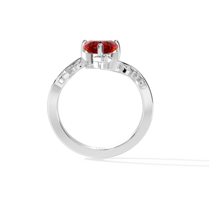Heart-shaped red gemstone ring with diamond leaf accents.