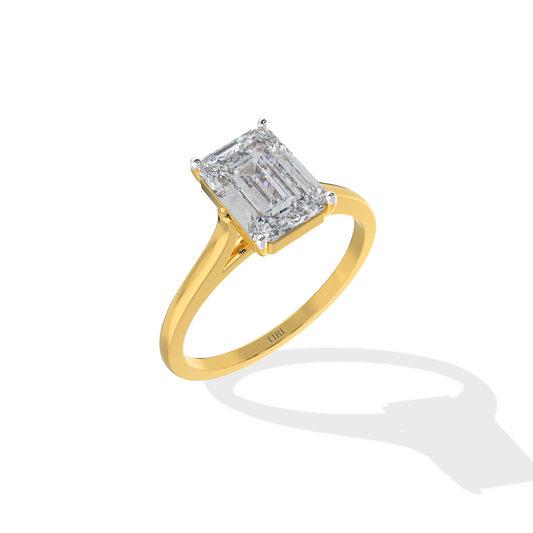 Emerald-cut solitaire diamond ring set in yellow gold.