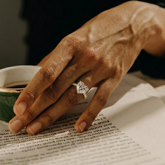 Hand with a ring holding a small cup of coffee on a newspaper