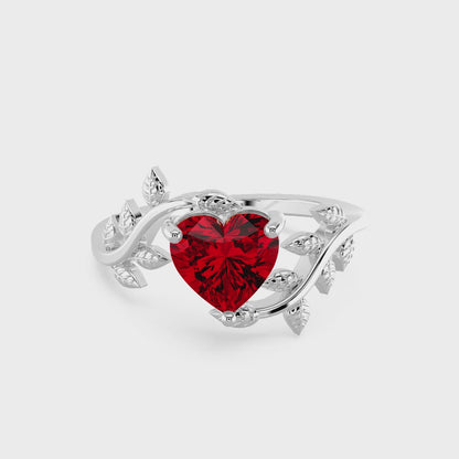 Heart-shaped red gemstone ring with diamond leaf accents.