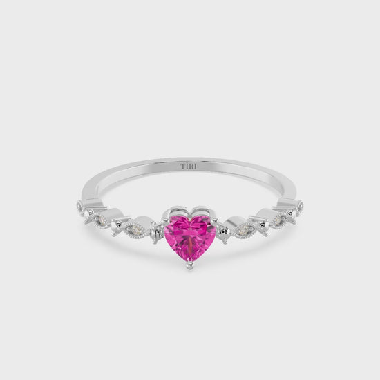 Silver ring with a pink heart-shaped gemstone on a white background