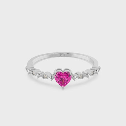 Silver ring with a pink heart-shaped gemstone on a white background