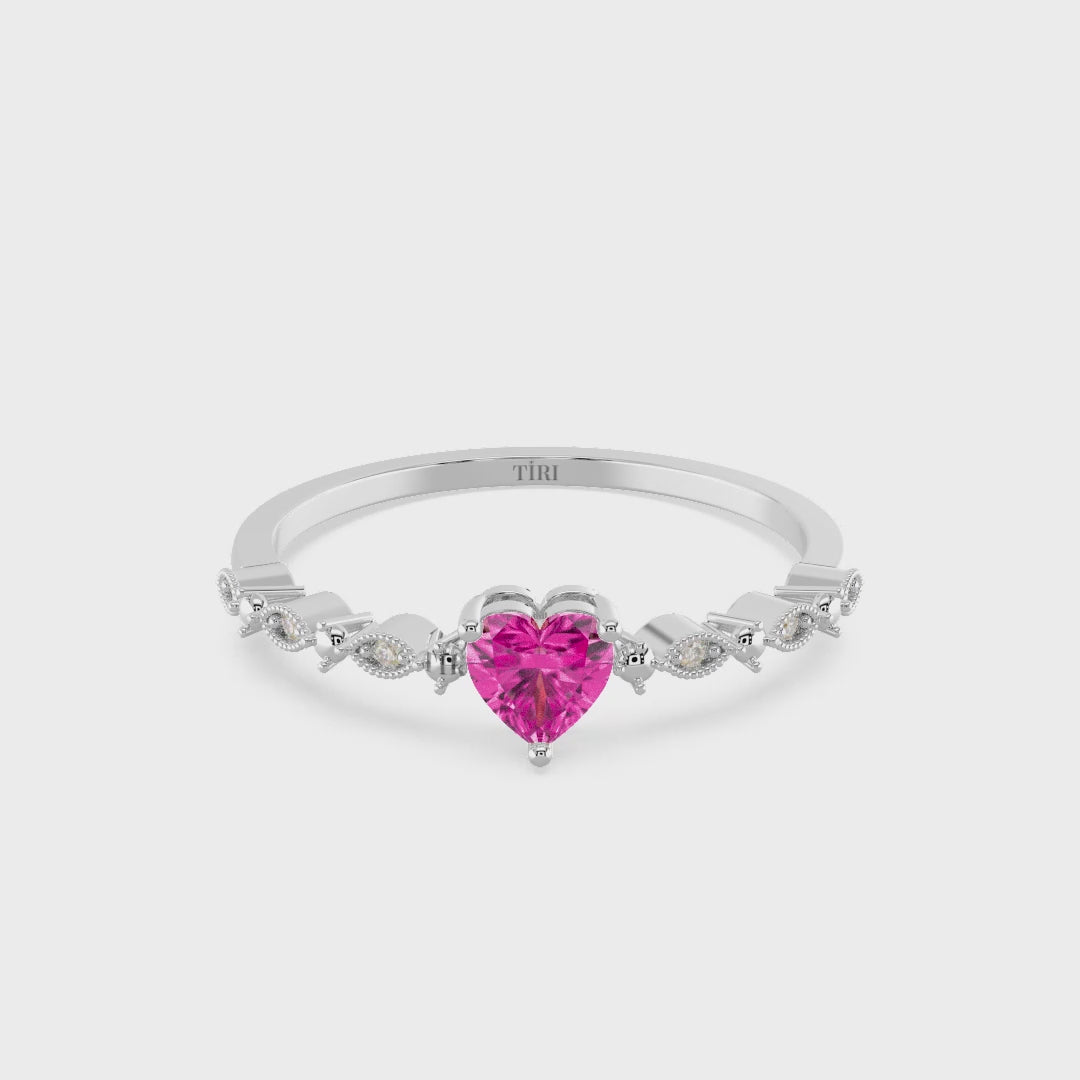 Silver ring with a pink heart-shaped gemstone on a white background