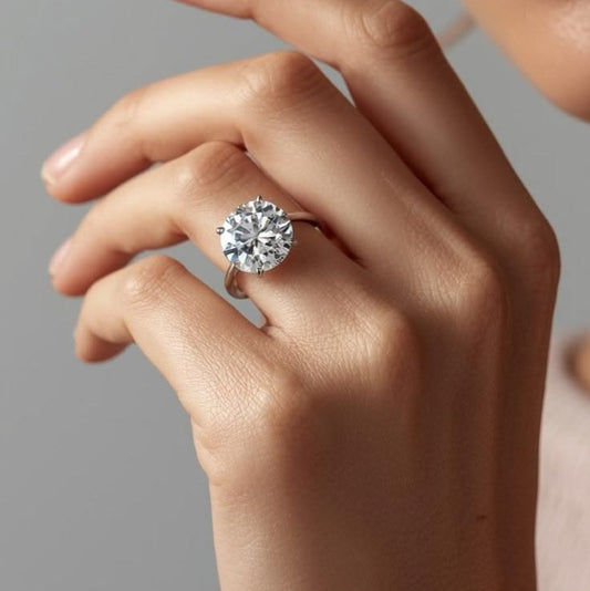 Close-up of a hand wearing a diamond ring on a neutral background
